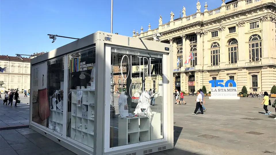 Stand fieristico rivestito con grafiche di etichette di vino su prato
