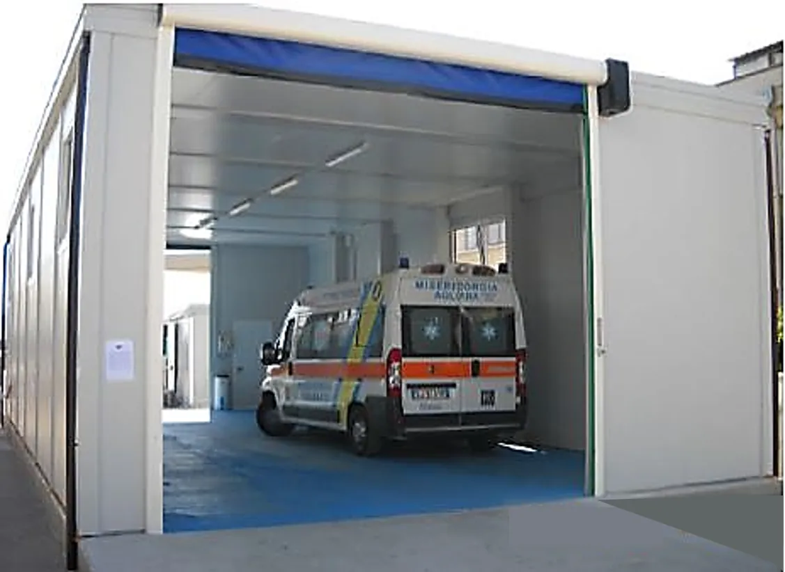 Ambulanza della Misericordia parcheggiata in un ricovero modulare con portone avvolgibile