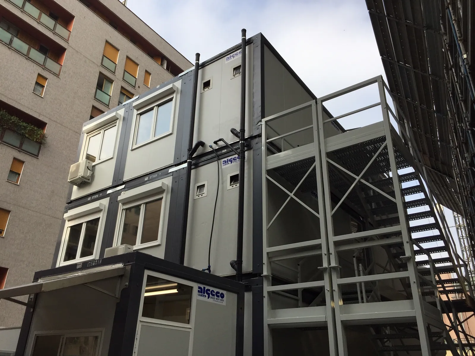 Moduli prefabbricati Algeco su due piani con scala esterna in acciaio in un cantiere urbano