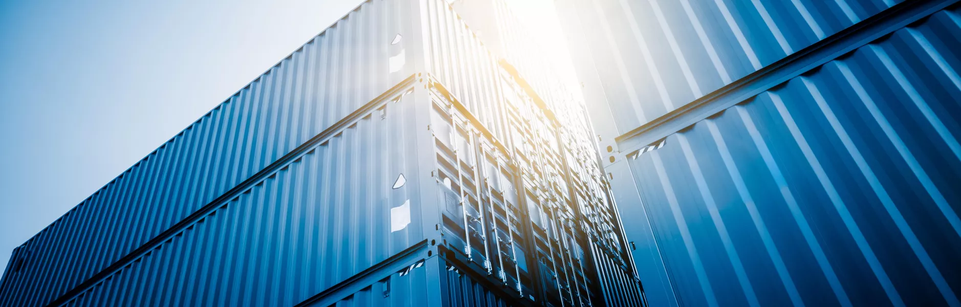 Container marittimi blu impilati ripresi dal basso in controluce
