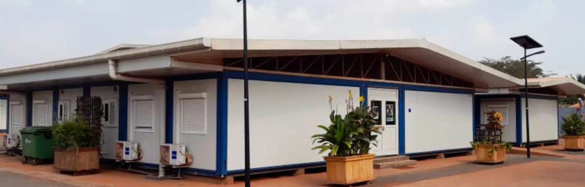 Complesso di moduli prefabbricati bianchi e blu con lampioni solari