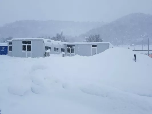 Moduli prefabbricati sepolti dalla neve in un piazzale di montagna