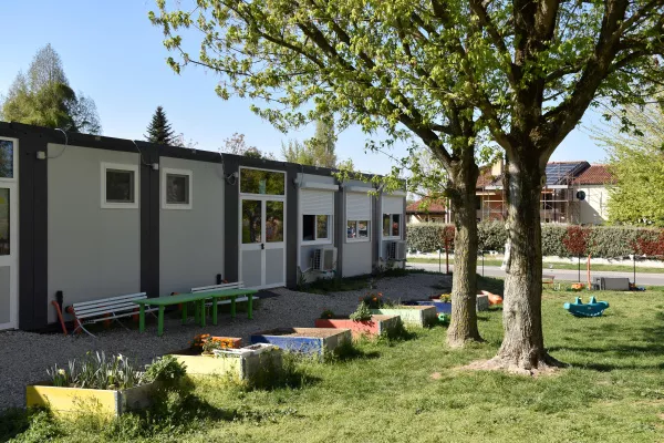 Scuola modulare a un piano con giardino alberato e orti didattici
