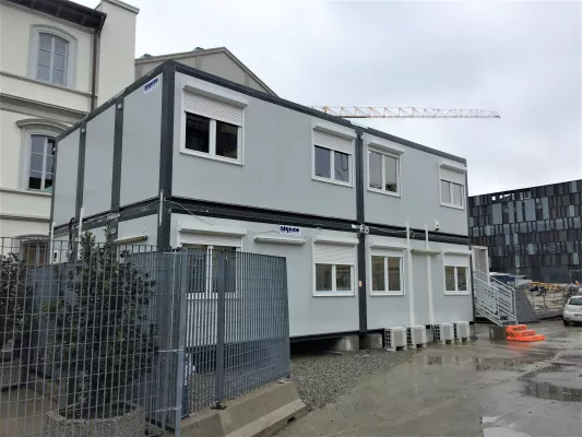 Uffici di cantiere su due piani con gru sullo sfondo
