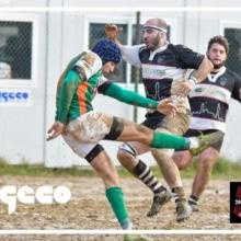 Giocatori di rugby si contendono la palla durante una partita davanti ai moduli